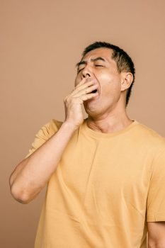 a sleepy man in yellow crew neck t shirt